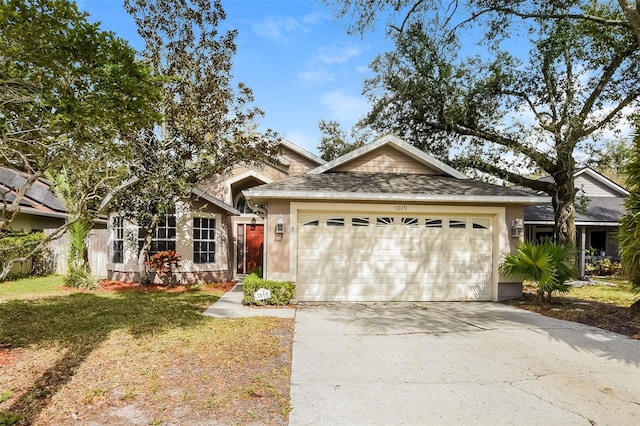 ranch-style house featuring a garage, a front yard, driveway, and stucco siding