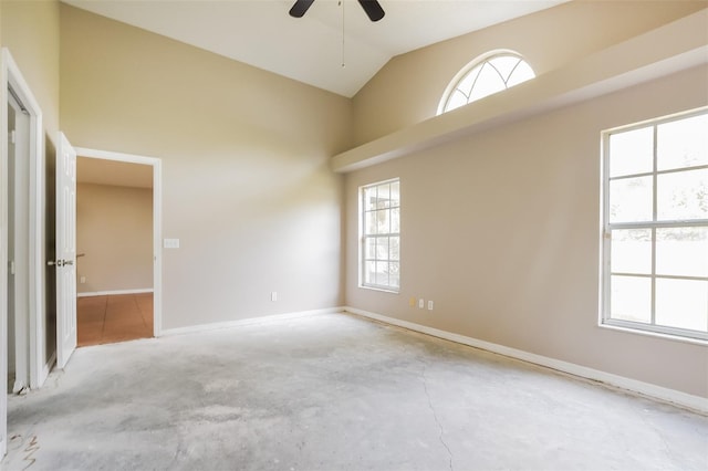 empty room featuring high vaulted ceiling, ceiling fan, unfinished concrete floors, and baseboards