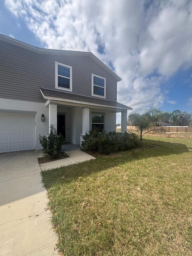 137 Willow Dr, Kissimmee, FL 34759 - view of front of house with a front yard, stucco siding, a garage, and concrete driveway