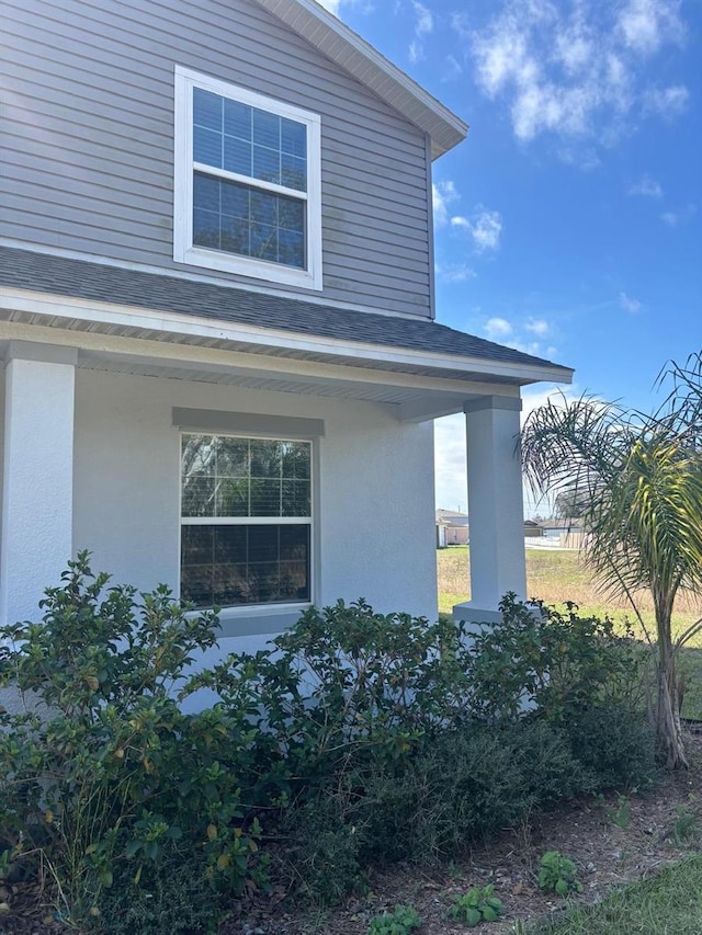 137 Willow Dr, Kissimmee, FL 34759 - view of home's exterior with roof with shingles, a porch, and stucco siding