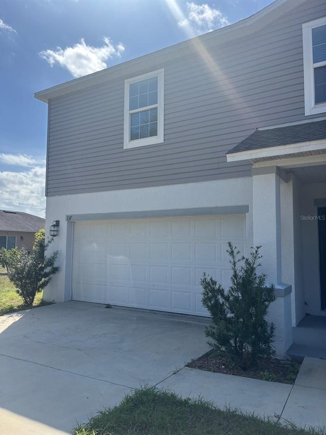 137 Willow Dr, Kissimmee, FL 34759 - view of home's exterior featuring a garage, concrete driveway, and stucco siding