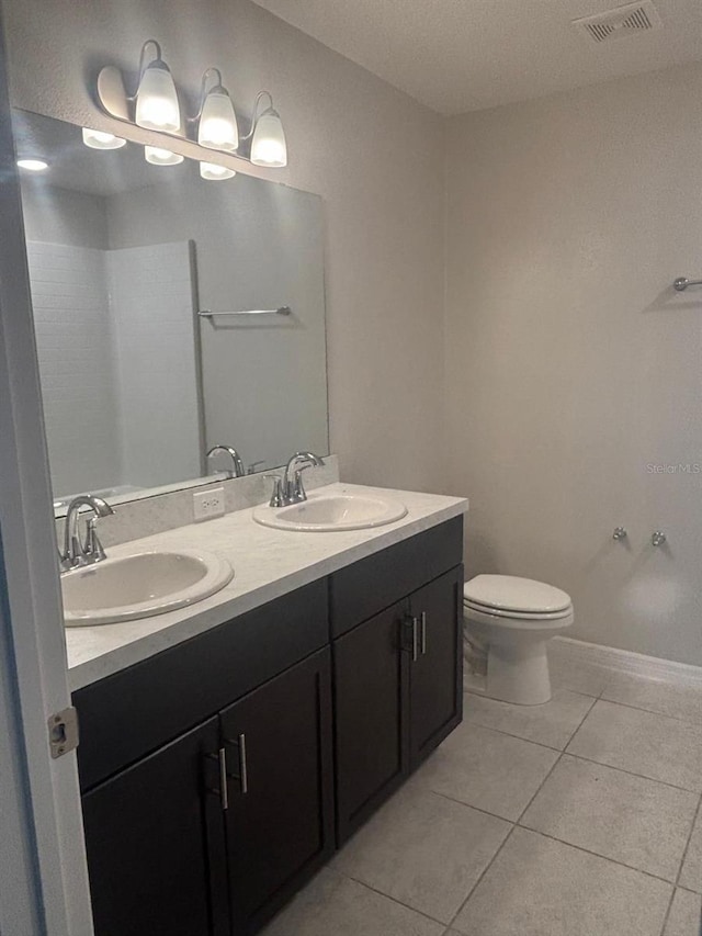 137 Willow Dr, Kissimmee, FL 34759 - full bath featuring tile patterned flooring, double vanity, toilet, and baseboards