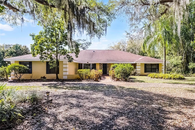 ranch-style house featuring brick siding