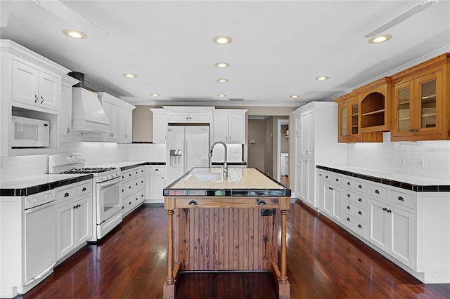 kitchen with white appliances, tile counters, glass insert cabinets, dark wood-type flooring, and custom exhaust hood