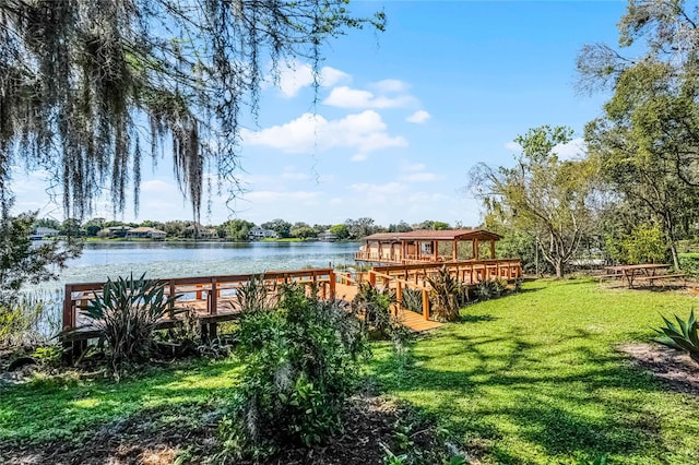 dock area with a water view and a yard