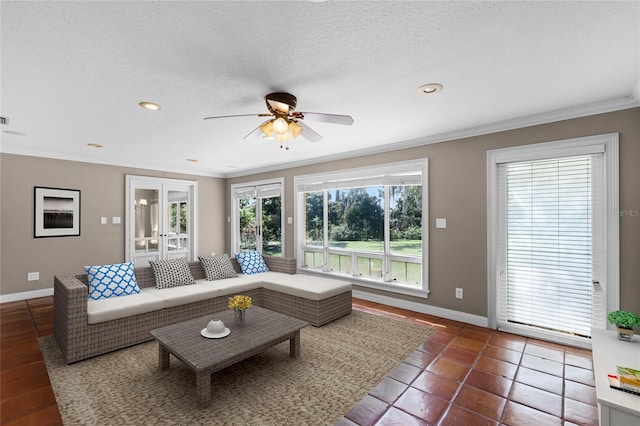 living room with a textured ceiling, french doors, ornamental molding, and baseboards