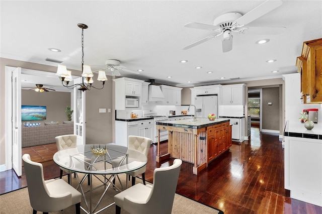 dining room featuring dark wood-style floors, crown molding, recessed lighting, visible vents, and baseboards