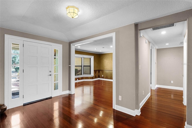 foyer entrance with a textured ceiling, recessed lighting, visible vents, baseboards, and wood-type flooring