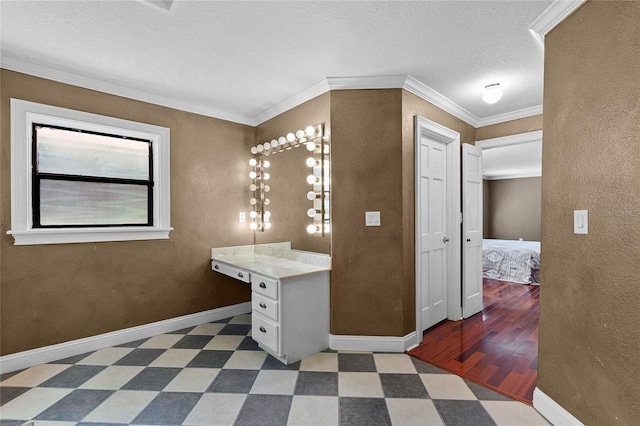 bathroom featuring baseboards, a textured wall, ornamental molding, and tile patterned floors