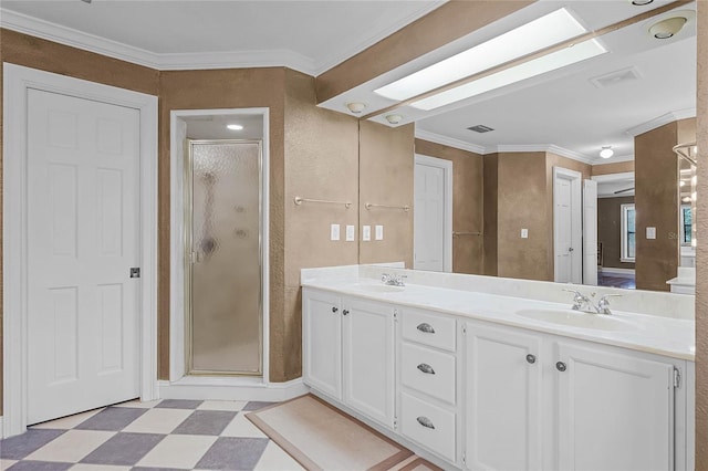 bathroom featuring crown molding, a skylight, a sink, and tile patterned floors