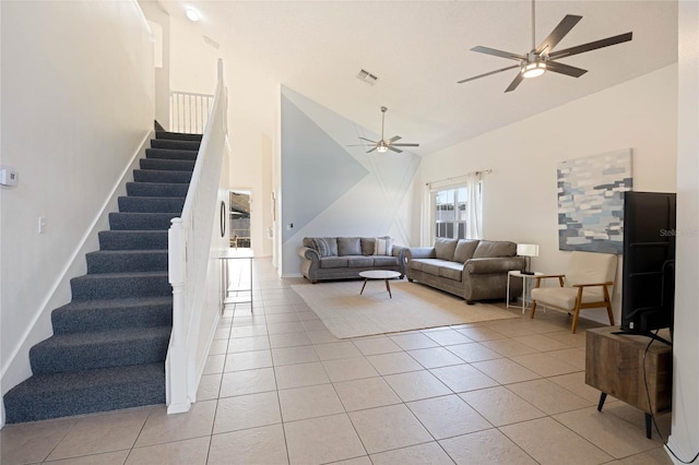 living area featuring light tile patterned floors, visible vents, stairway, ceiling fan, and high vaulted ceiling