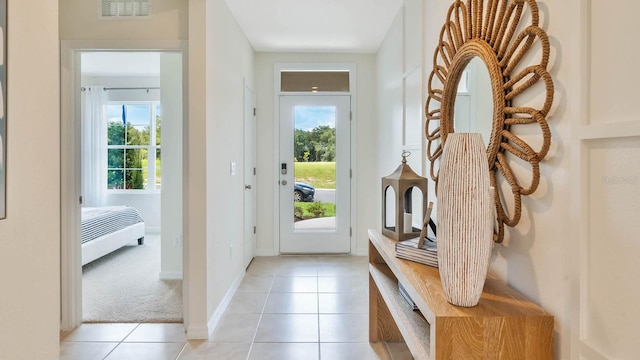 doorway to outside featuring visible vents, baseboards, and light tile patterned flooring