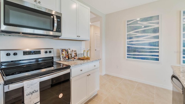 kitchen featuring baseboards, appliances with stainless steel finishes, light stone countertops, and white cabinets