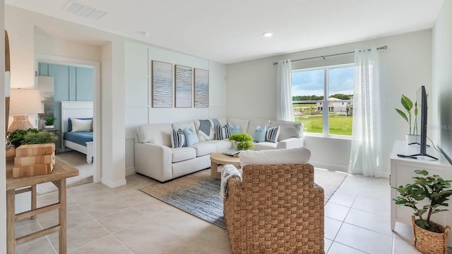 living room with light tile patterned floors, baseboards, and visible vents