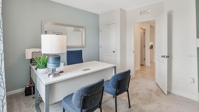 office space featuring baseboards, visible vents, and light colored carpet