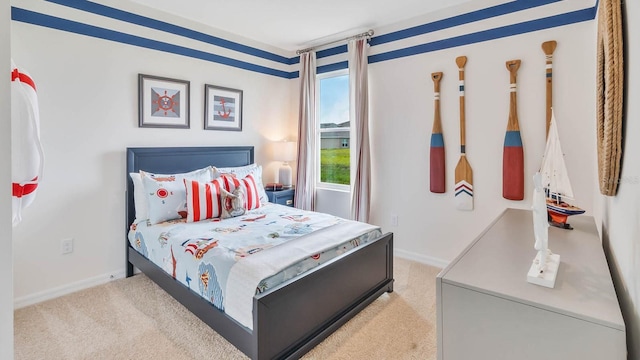 bedroom with baseboards and light colored carpet