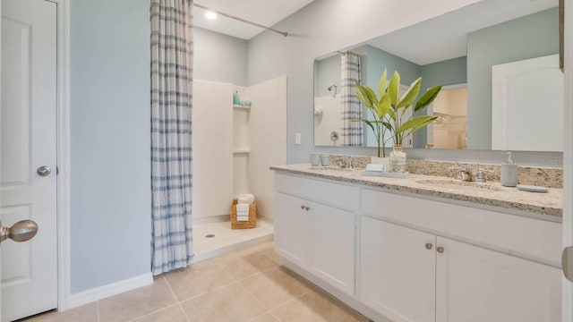 bathroom featuring double vanity, tile patterned flooring, a shower stall, and a sink