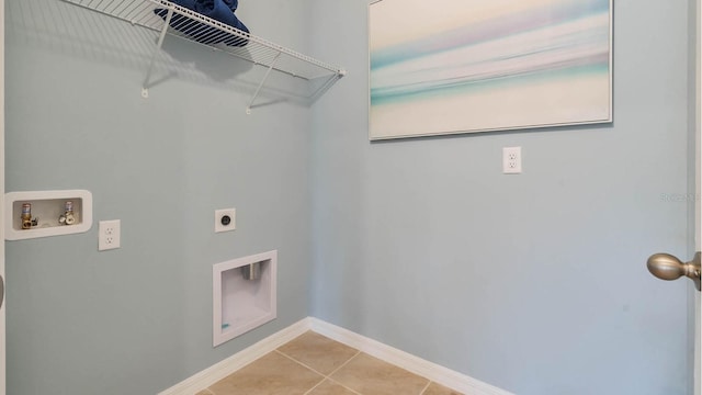 clothes washing area with light tile patterned flooring, hookup for a washing machine, hookup for an electric dryer, laundry area, and baseboards