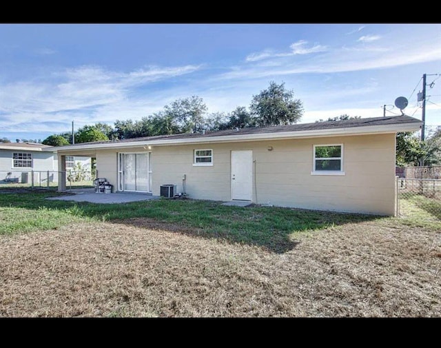 back of property with a yard, a patio area, fence, and central air condition unit