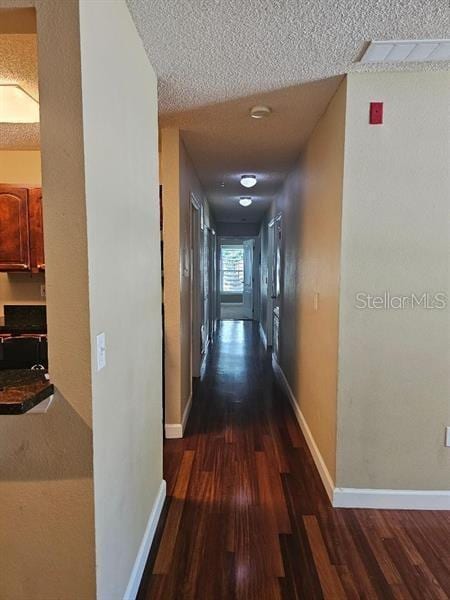 2019 Dixie Belle Dr Unit 2019O, Orlando, FL 32812 - hallway with dark wood-type flooring, a textured ceiling, and baseboards