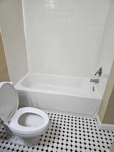 2019 Dixie Belle Dr Unit 2019O, Orlando, FL 32812 - bathroom featuring shower / bath combination, toilet, and baseboards