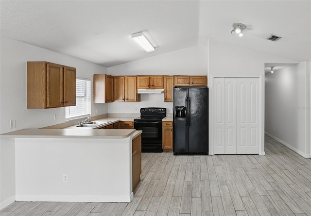 kitchen with light countertops, visible vents, light wood-style floors, a sink, and black appliances