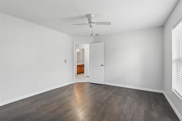 unfurnished room with dark wood-style flooring and baseboards