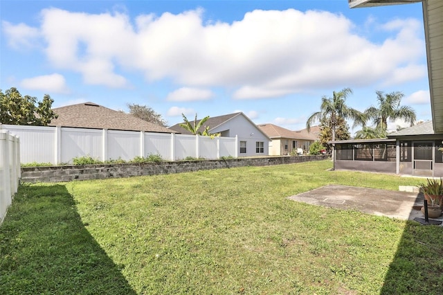 view of yard featuring a residential view, a patio area, a fenced backyard, and a sunroom