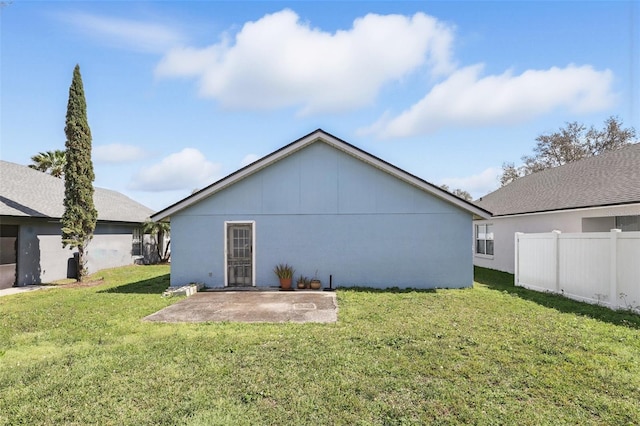 rear view of house with a patio area, fence, and a lawn