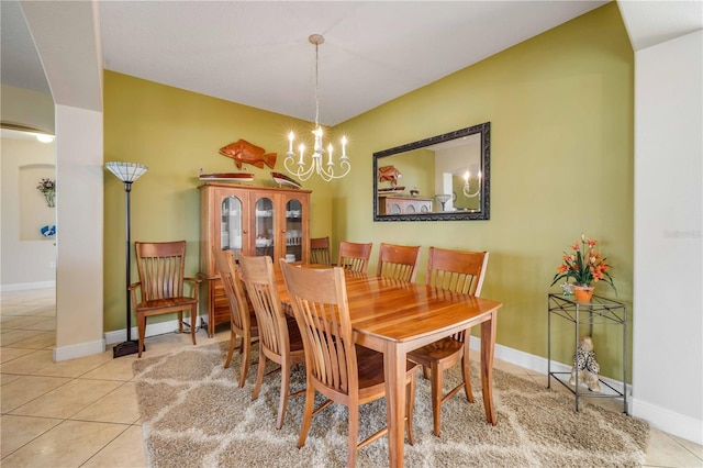 dining space with a chandelier, baseboards, and light tile patterned floors