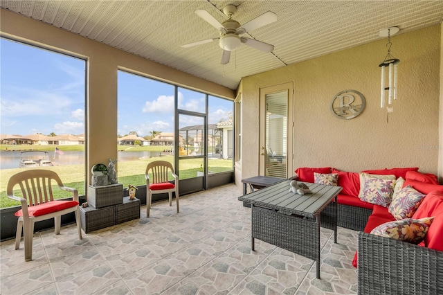 sunroom / solarium with a water view and ceiling fan