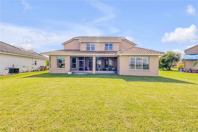 back of property featuring a yard, stucco siding, a sunroom, cooling unit, and a tiled roof