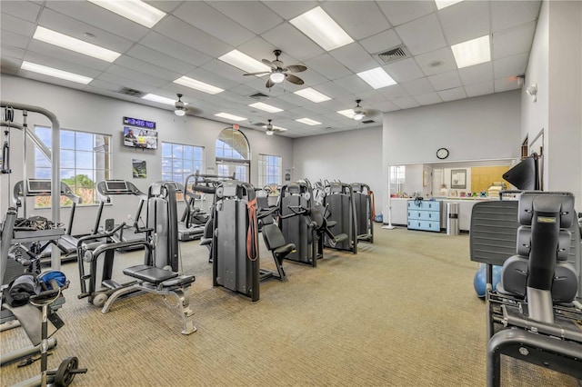 exercise room with a high ceiling, a paneled ceiling, carpet, and visible vents