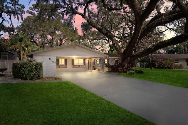 ranch-style home featuring brick siding and a front lawn