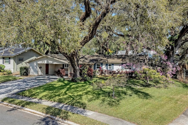 ranch-style house featuring driveway and a front yard