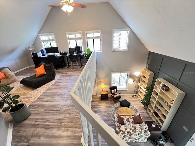 office area featuring a healthy amount of sunlight, high vaulted ceiling, and wood finished floors