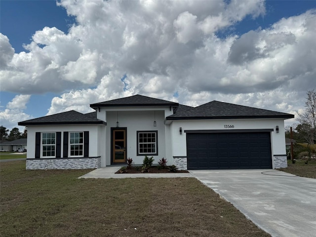 prairie-style house featuring a garage, a front yard, driveway, and stucco siding