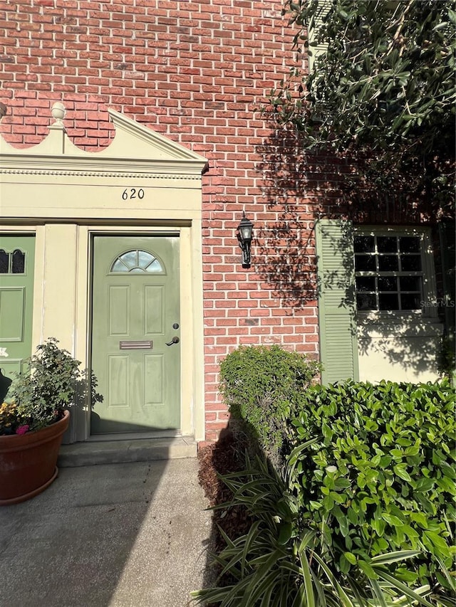 doorway to property featuring brick siding