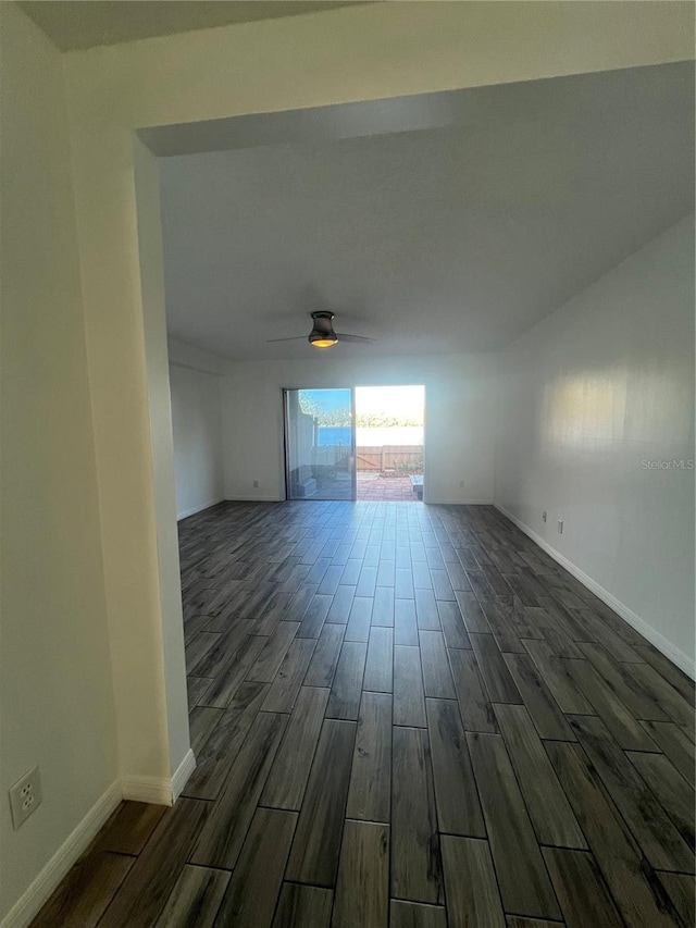 empty room with wood finish floors, a ceiling fan, and baseboards