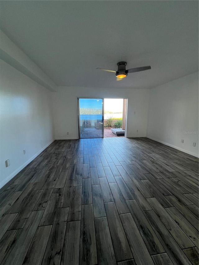 unfurnished living room featuring a ceiling fan, dark wood-style flooring, and baseboards