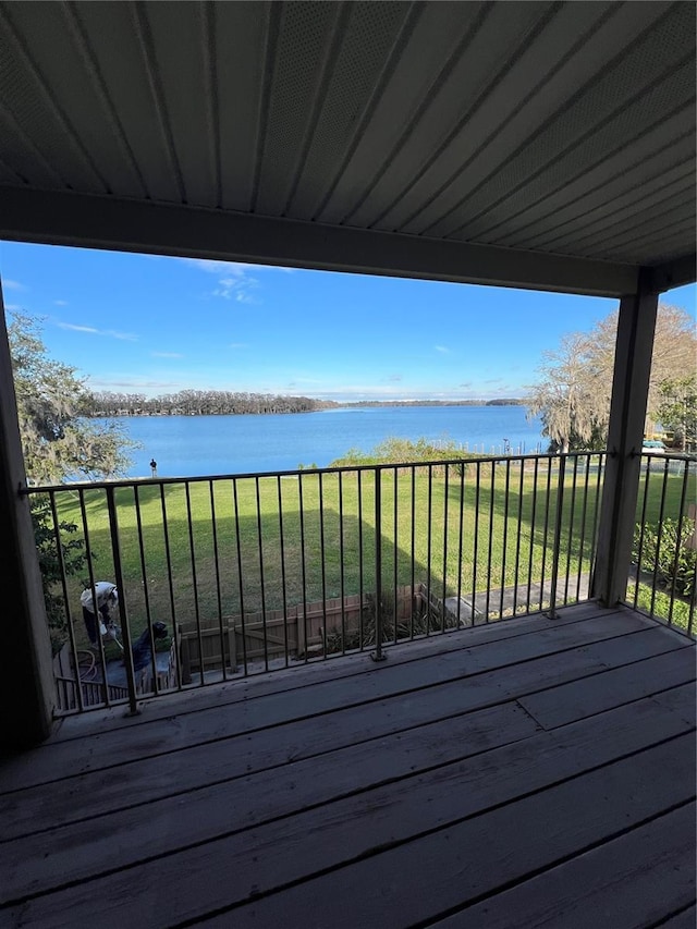 wooden terrace with a lawn and a water view