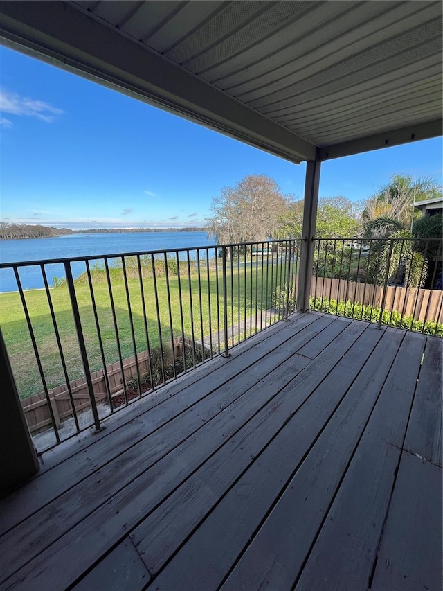 wooden deck featuring a water view and a lawn