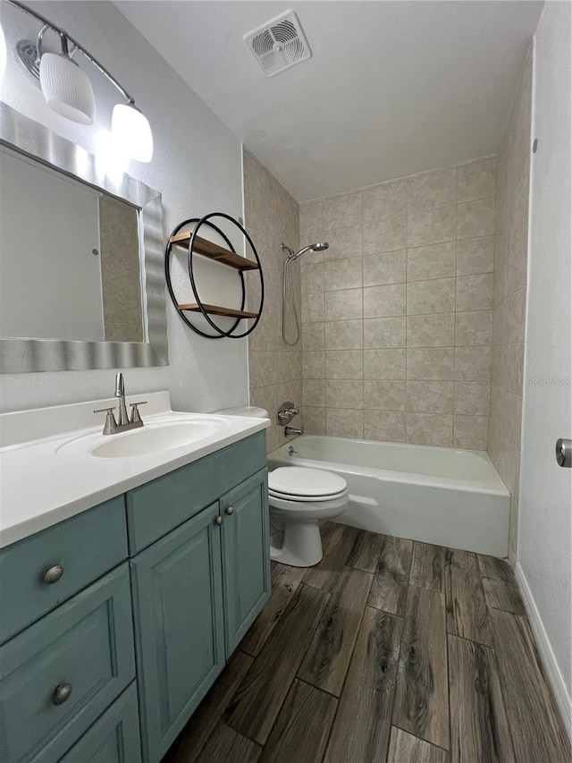 full bath featuring wood finish floors, shower / bath combination, visible vents, toilet, and vanity