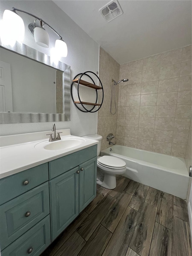 full bathroom with visible vents, toilet, wood finished floors, tub / shower combination, and vanity