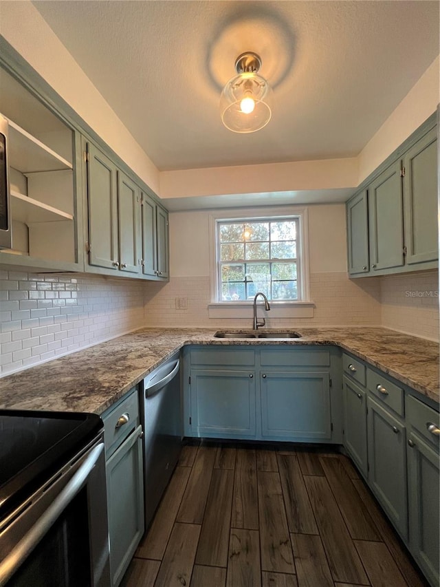 kitchen featuring dishwasher, light stone countertops, wood finish floors, open shelves, and a sink