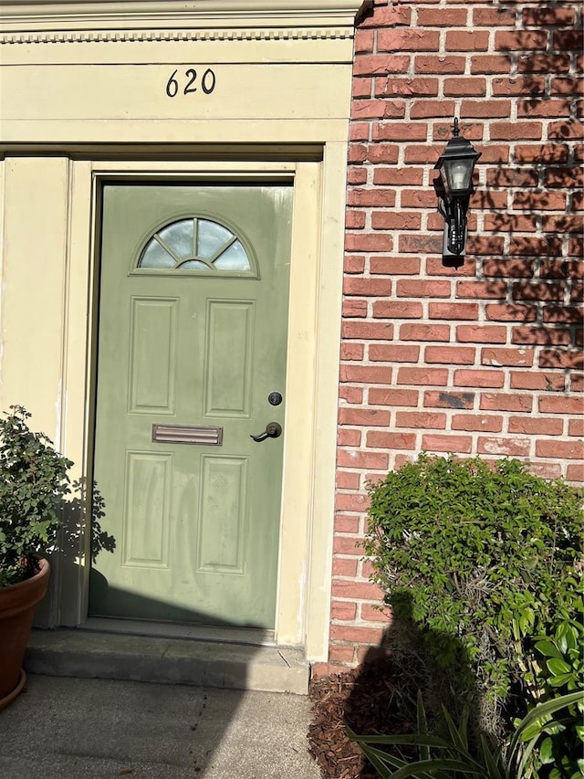 property entrance featuring brick siding