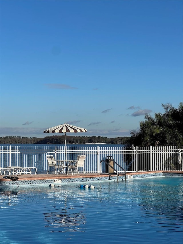 view of swimming pool featuring fence