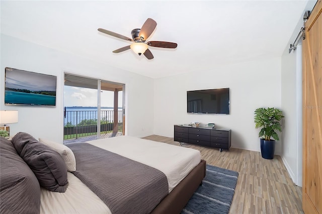 620 Georgetown Dr Unit 620, Casselberry, FL 32707 - bedroom with access to exterior, a barn door, light wood-type flooring, and a ceiling fan