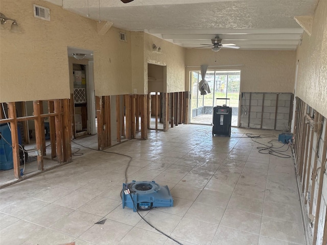 unfurnished room featuring a textured ceiling, visible vents, a ceiling fan, and light tile patterned flooring