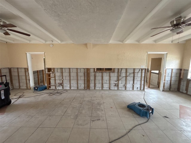 spare room with ceiling fan and beamed ceiling